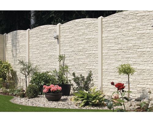 Clôture en béton avec plantes et pierres dans le jardin