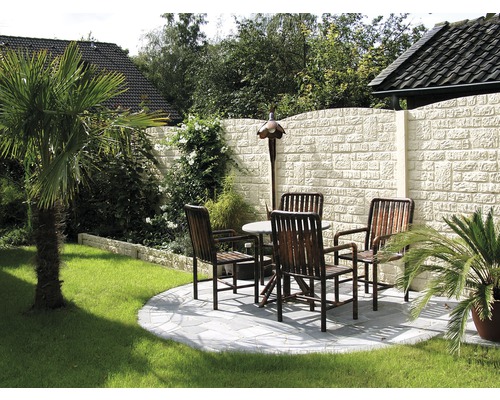 Jardin avec mur en pierre, pelouse, palmiers, table et chaises