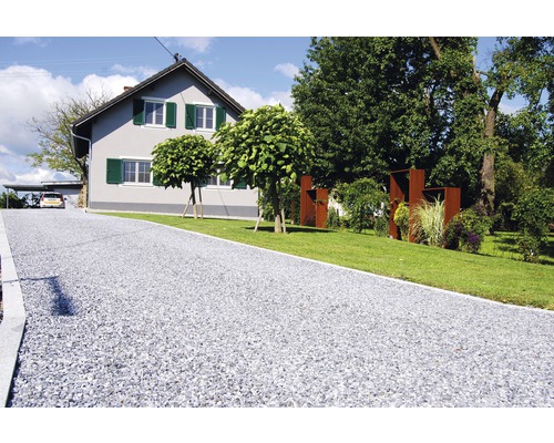 Allée en gravier devant une maison d''habitation avec jardin