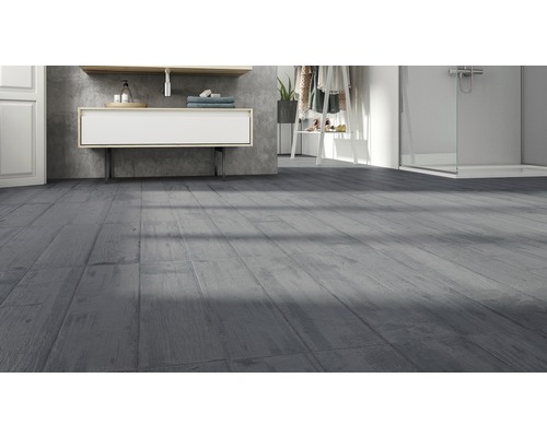 Salle de bain avec carrelage gris aspect bois, lavabo et douche.