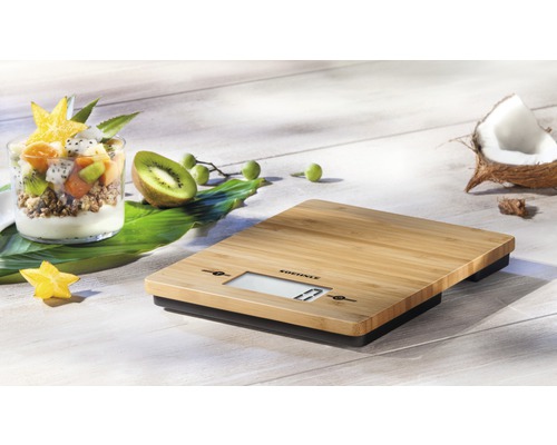 Digitale Küchenwaage aus Bambus mit Schale und tropischen Früchten.