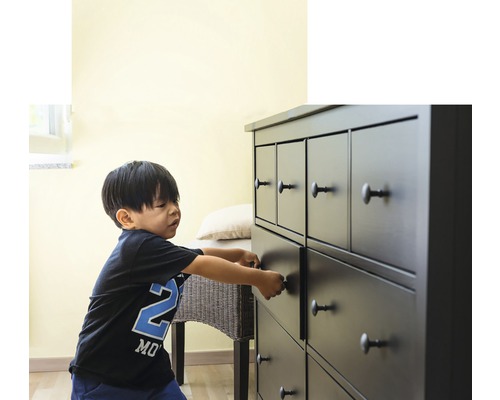 Enfant ouvrant le tiroir d''une commode à plusieurs tiroirs