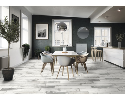 Salle à manger avec table à manger, chaises et carrelage de sol imitation bois.