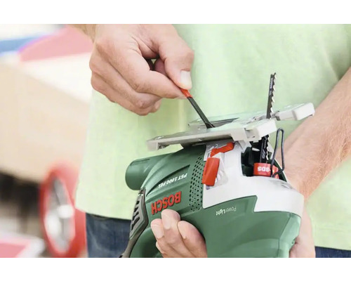 Une personne change la lame d''une scie sauteuse.