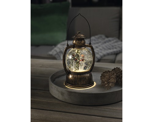 Lanterne à boule à neige décorative avec bonhomme de neige et sapin de Noël sur un plateau