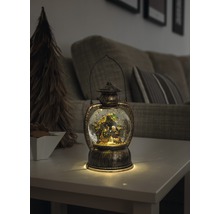 Lanterne décorative avec boule à neige et crèche sur une table