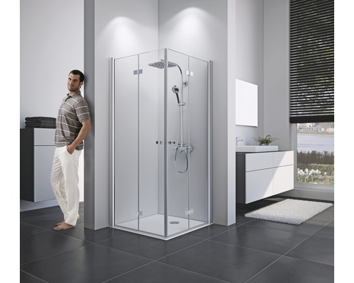 Salle de bains lumineuse avec douche d''angle, meuble sous-lavabo et personne debout