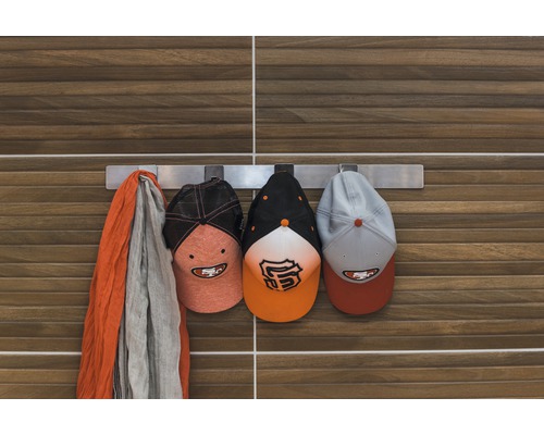 Barre de crochet avec bonnet et écharpe devant un mur en bois