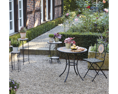 Gartenszene mit Bistrotisch, Stuhl und Pflanzenständern im Aussenbereich