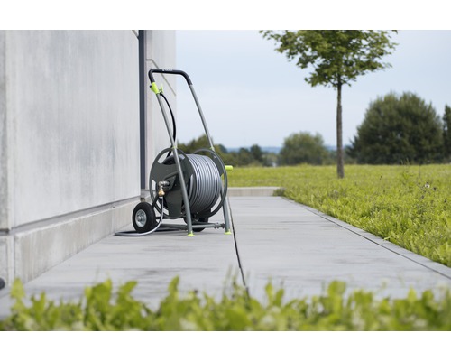 Gartenschlauchwagen mit aufgerolltem Schlauch im Gartenbereich