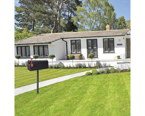 Boîte aux lettres sur la pelouse devant une maison d''habitation