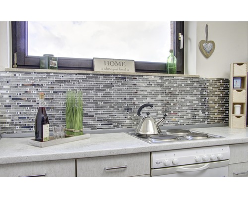 Scène de cuisine avec des carreaux de mosaïque, une plaque de cuisson, une bouilloire et des décorations