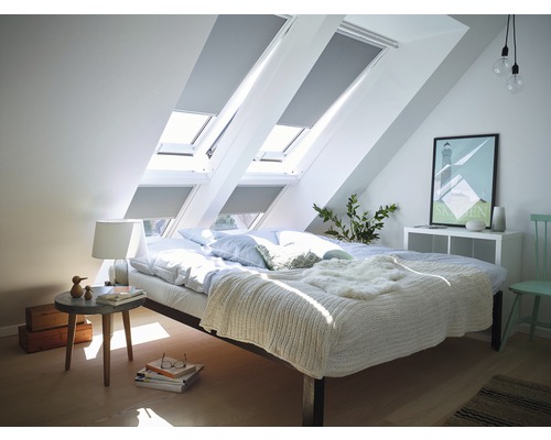 Chambre mansardée avec fenêtres de toit et stores occultants