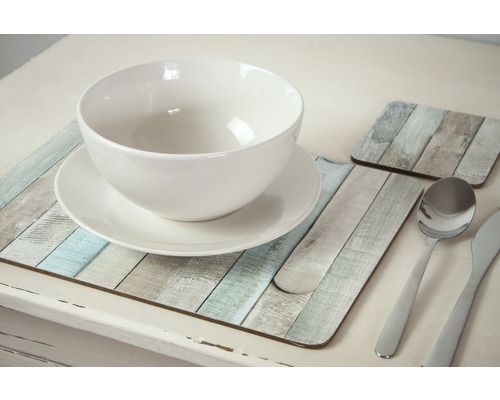 Gedeckter Tisch mit weisser Schüssel, Teller, Besteck und Untersetzern im Holzdesign