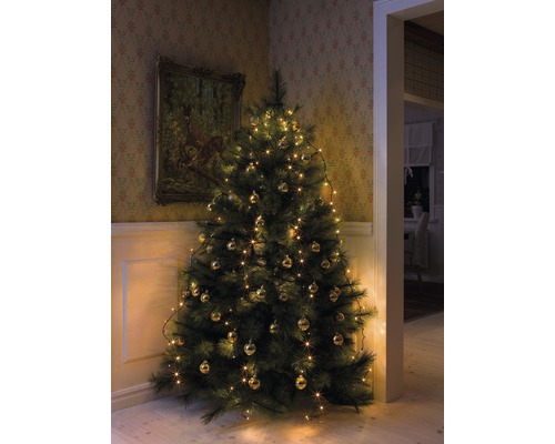 Sapin de Noël décoré avec des lumières et des boules dans une pièce décorée