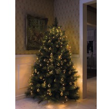 Sapin de Noël décoré avec des boules et des guirlandes lumineuses dans un coin de la pièce