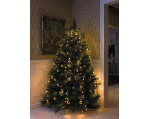 Sapin de Noël décoré avec des boules et des guirlandes lumineuses dans un coin de la pièce