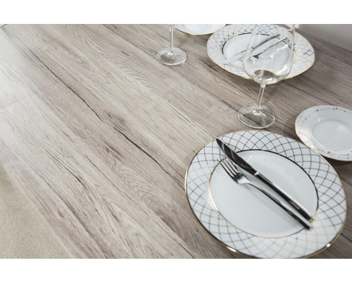 Table à manger avec vaisselle et couverts sur un plateau de table aspect bois