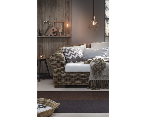 Salon avec canapé en rotin, coussins et suspension