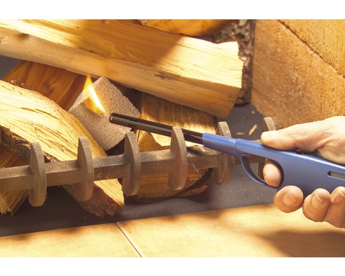 Personne allumant du bois de chauffage avec un briquet à allumage long