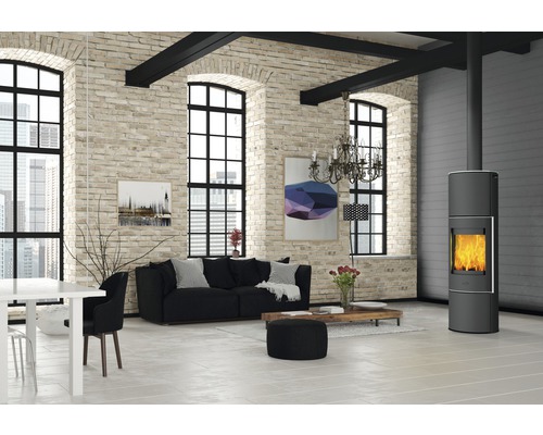 Salon avec poêle à bois, canapé et table à manger dans une pièce lumineuse avec mur en briques