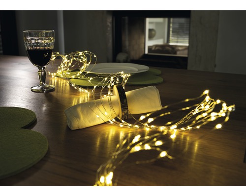 Décoration de table avec guirlande lumineuse, verre et vaisselle
