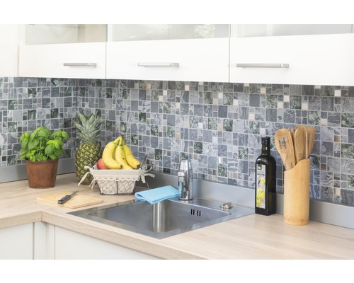 Cuisine claire avec mosaïque, évier en acier inoxydable et ingrédients frais.