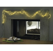 Cheminée décorative avec guirlande lumineuse et table dressée pour une ambiance chaleureuse