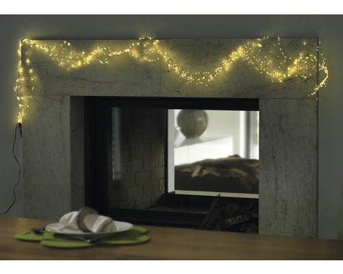 Cheminée décorative avec guirlande lumineuse et table dressée pour une ambiance chaleureuse