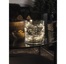 Guirlande lumineuse décorative dans un récipient en verre sur une table