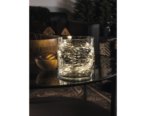 Guirlande lumineuse décorative dans un récipient en verre sur une table