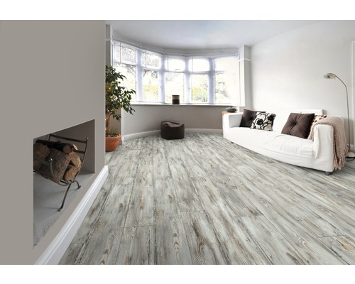 Salon avec plancher en bois clair, canapé et bois de cheminée