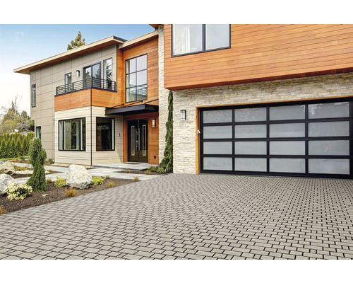 Maison moderne avec allée pavée et garage avec porte en verre