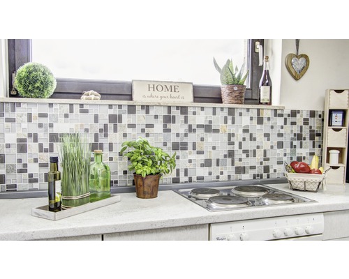 Scène de cuisine avec mur en carreaux de mosaïque, plaque de cuisson et éléments décoratifs