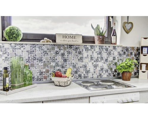 Gros plan d''une cuisine moderne avec des carreaux de mosaïque comme crédence, une cuisinière et divers objets de décoration.