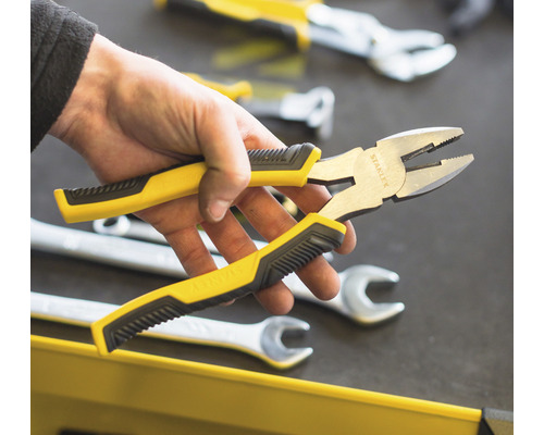 Pince universelle Stanley avec poignée jaune et noire dans la main