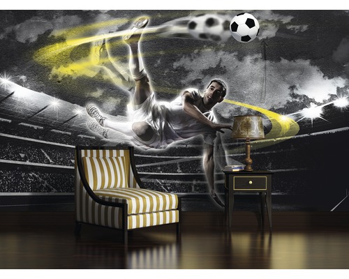 Papier peint avec motif de football, fauteuil et table de chevet dans une pièce.