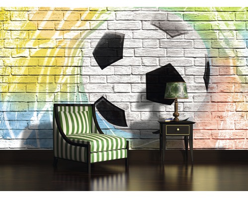 Salon avec fauteuil, table d''appoint et un mur avec un motif de football