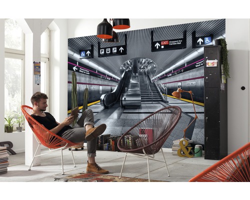 Espace de vie avec une fresque murale d''une station de métro, homme sur une chaise