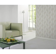 Pièce décorée avec fauteuil, lampadaire et papier peint à motifs