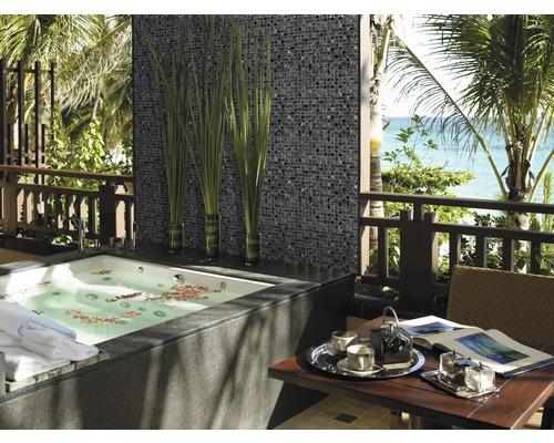 Badezimmer mit Mosaikwand, Badewanne und Tisch auf einer Terrasse mit Meerblick