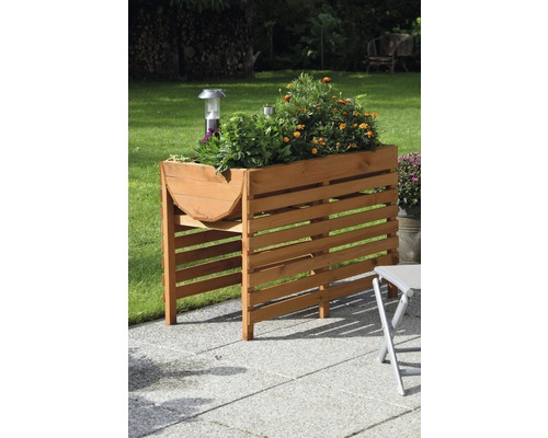 Jardinière surélevée en bois avec plantation dans le jardin.