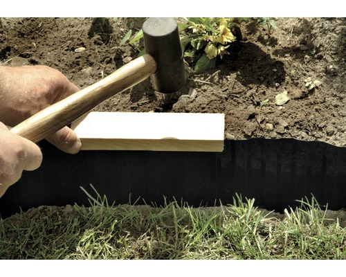 Installation einer Rasenkante mit Hammer und Holzbrett