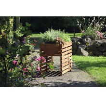 Jardinière sur pieds en bois avec herbes et plantes dans le jardin