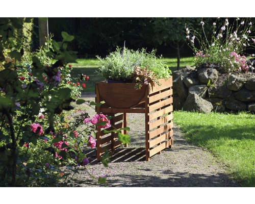 Jardinière sur pieds en bois avec herbes et plantes dans le jardin