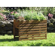 Jardinière en bois avec diverses herbes et plantes dans le jardin.