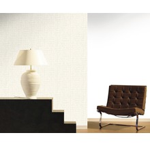 Papier peint clair avec motif, lampe sur escalier et fauteuil dans la pièce