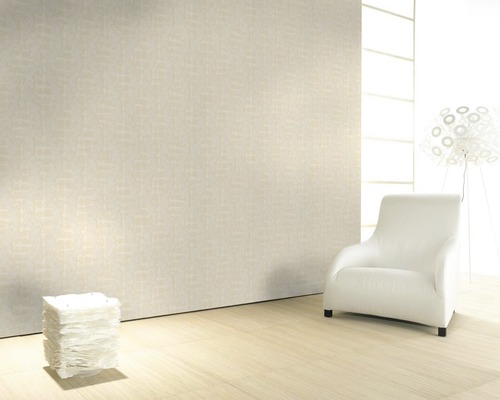 Pièce lumineuse avec papier peint à motifs, fauteuil et lampes pour une atmosphère conviviale.