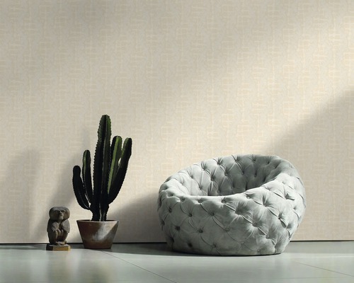 Salon avec papier peint à motifs, fauteuil et cactus