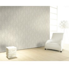 Pièce lumineuse avec papier peint à motifs, fauteuil et éclairage décoratif pour une ambiance moderne.